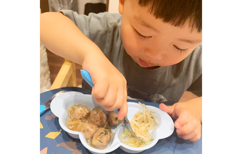もやしの和え物を頬張る子ども