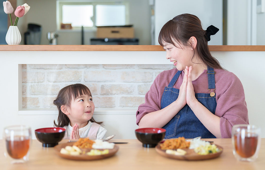 いただきますと一緒にする子どもとお母さん